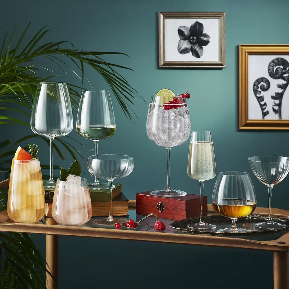 Elegant fluted highballs glass set with cocktails, stylish glassware collection.