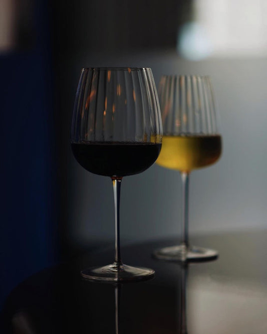 Fluted crystal wine glasses filled with red and white wine.