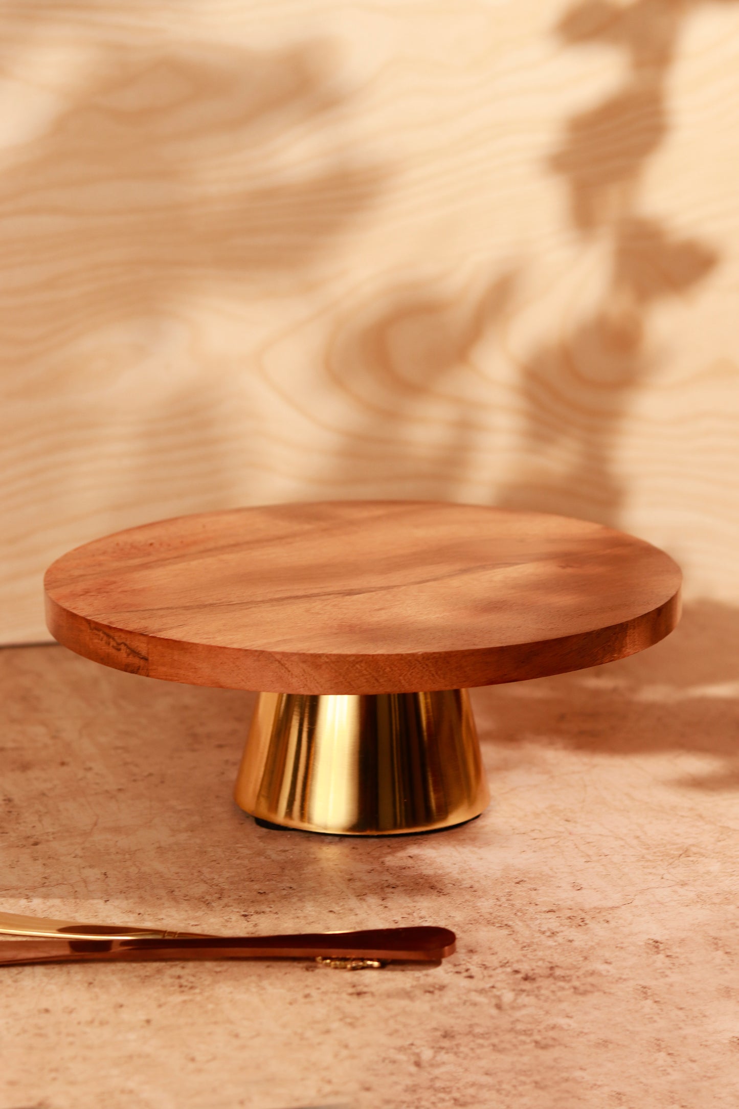 Wooden cake holder with golden metal base.