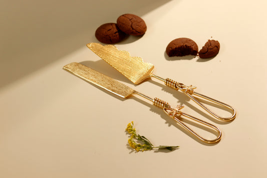 Golden firefly dessert knife and server set with cookies.