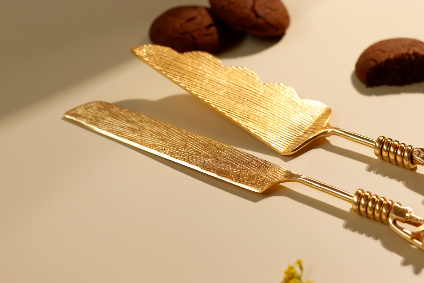 Golden cake server and knife set with decorative handles.
