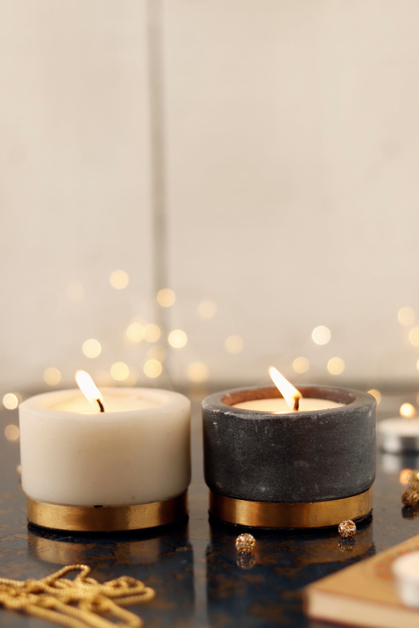 Elegant marble candle set with a sleek gold base and a warm glow.