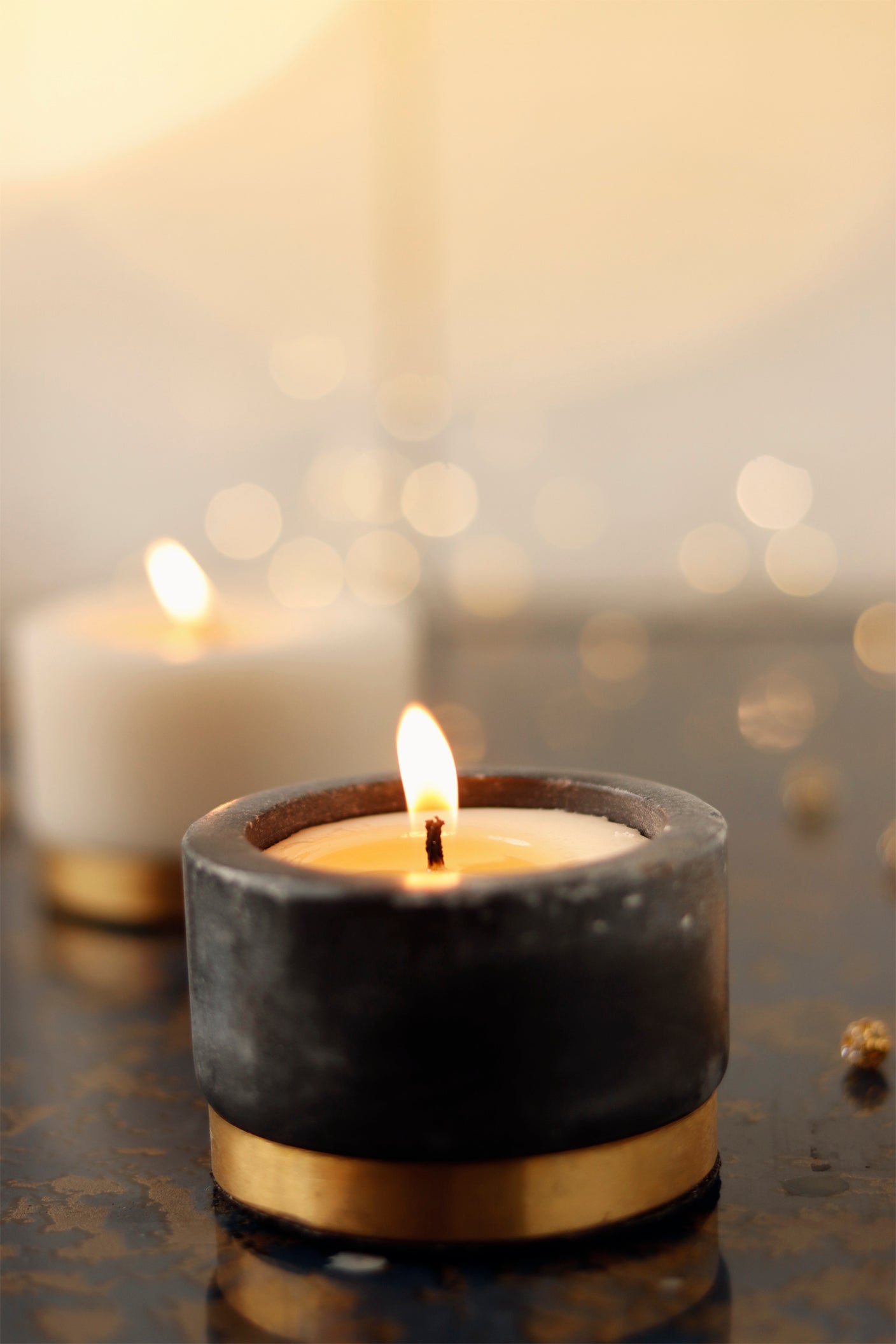 Lit marble candle with gold accent creating a relaxing ambiance