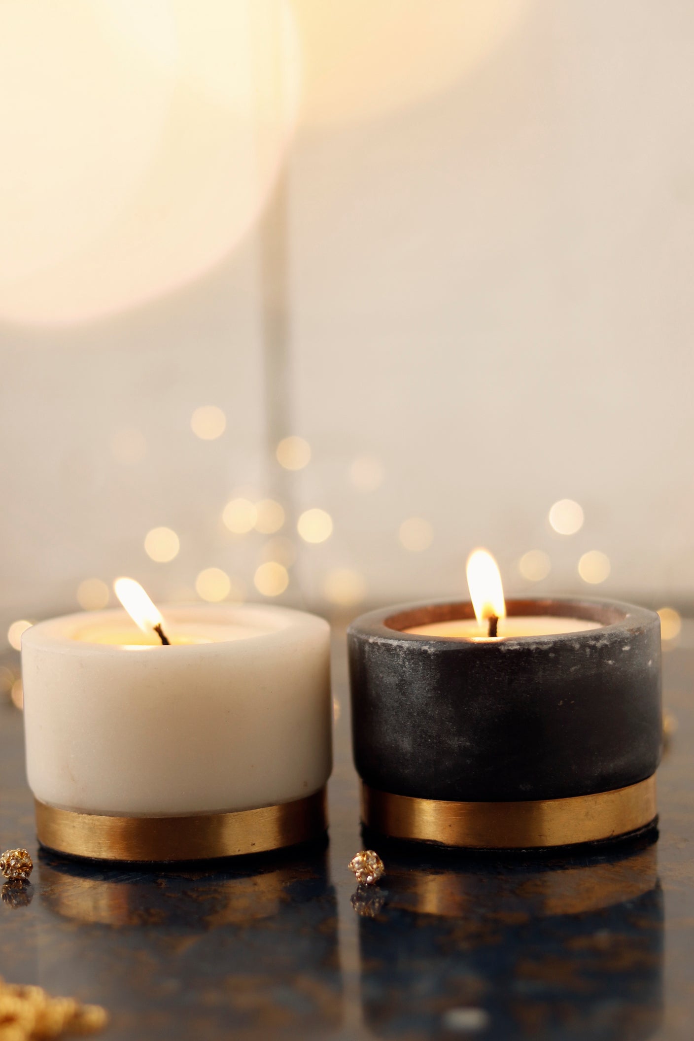 Lit marble candle set with gold accents, black and white.