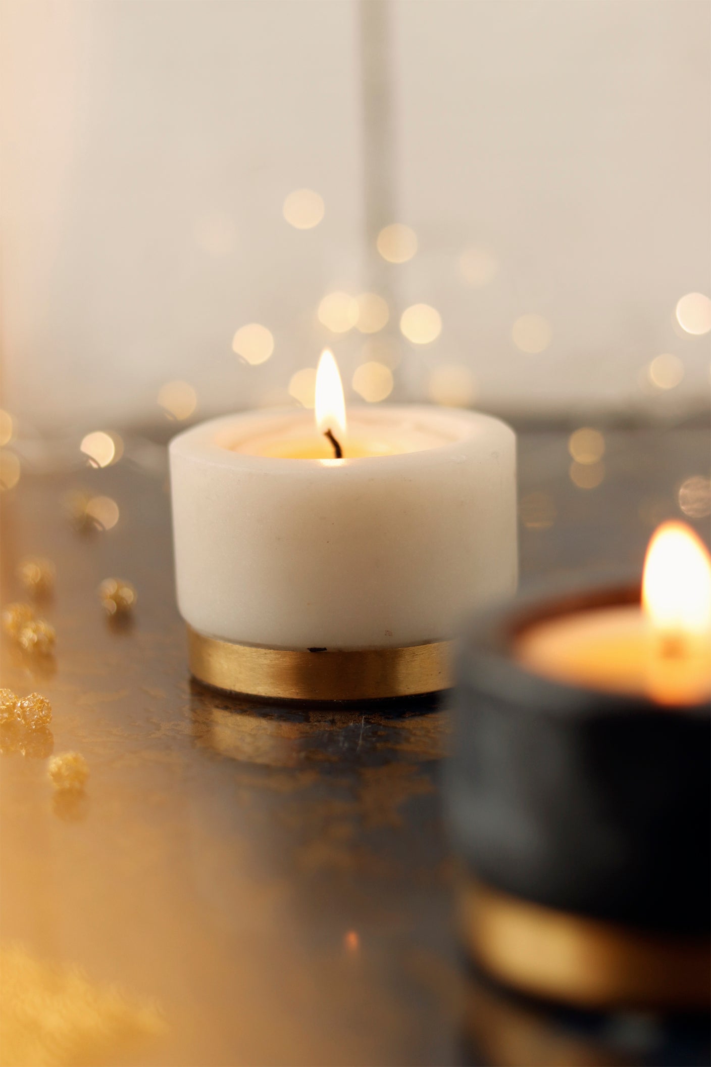 Burning candle with white marble and gold accents