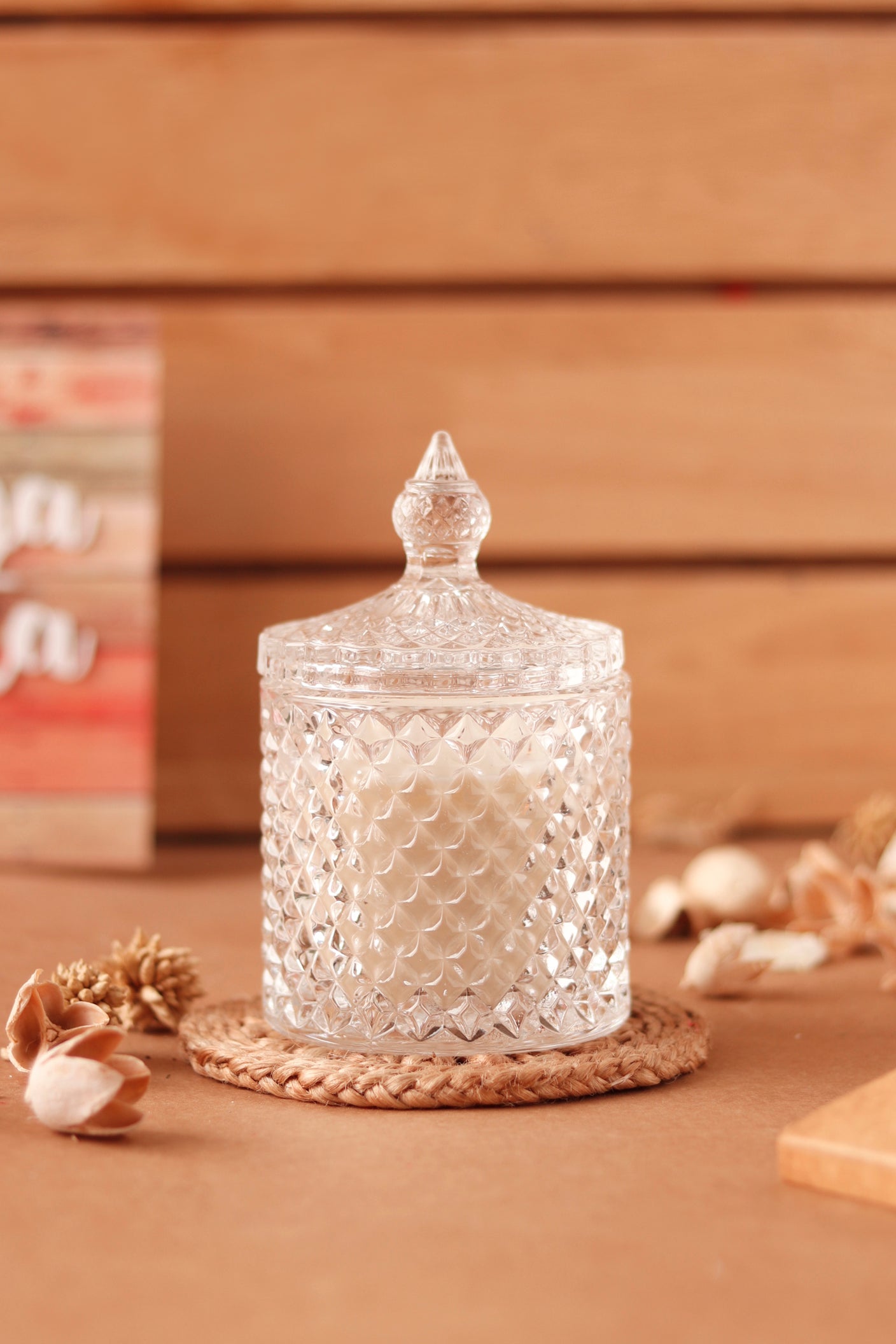 Elegant crystal jar candle with decorative lid on coaster.
