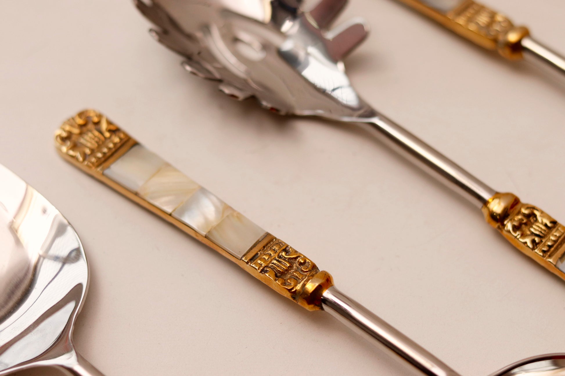 Elegant MOP serving spoons with gold accents, part of a six-piece set.