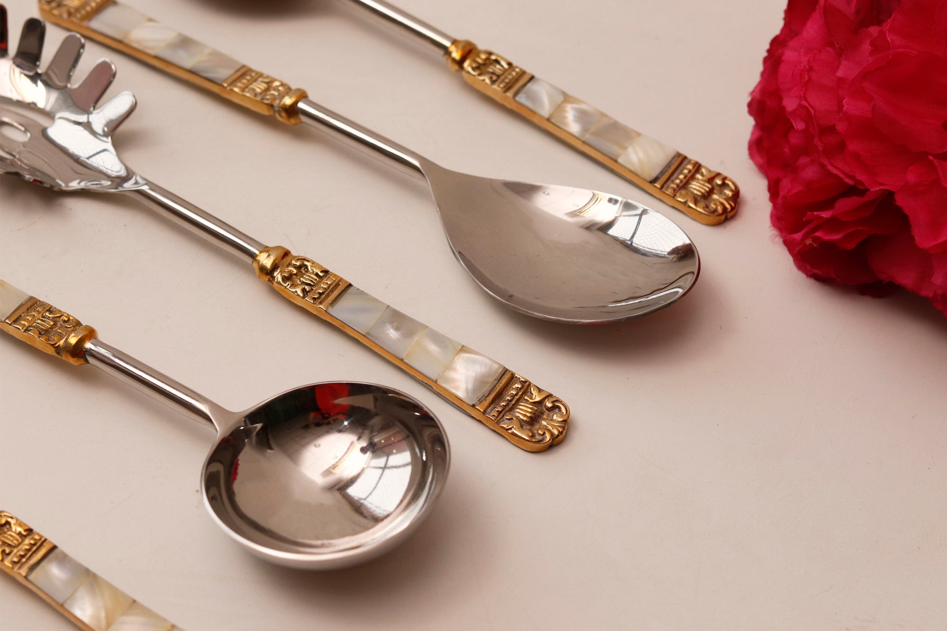 Elegant serving spoons with mother of pearl and gold accents.
