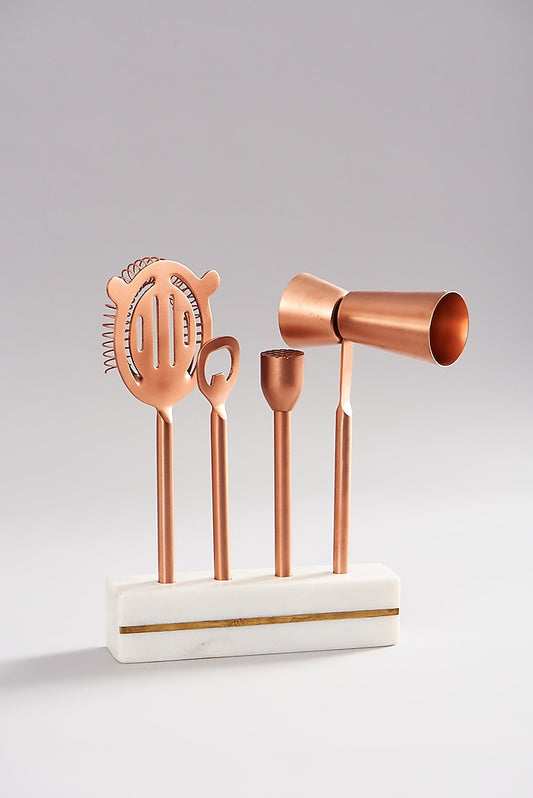 Copper bar accessories with a stylish marble stand for a modern bar setup.