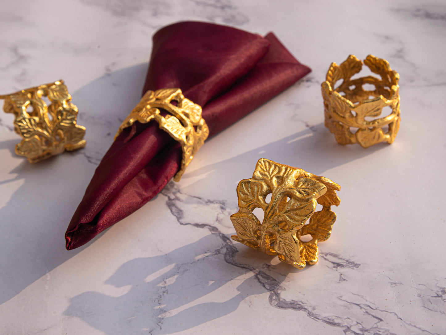Elegant golden leaf design napkin rings on a table setting.