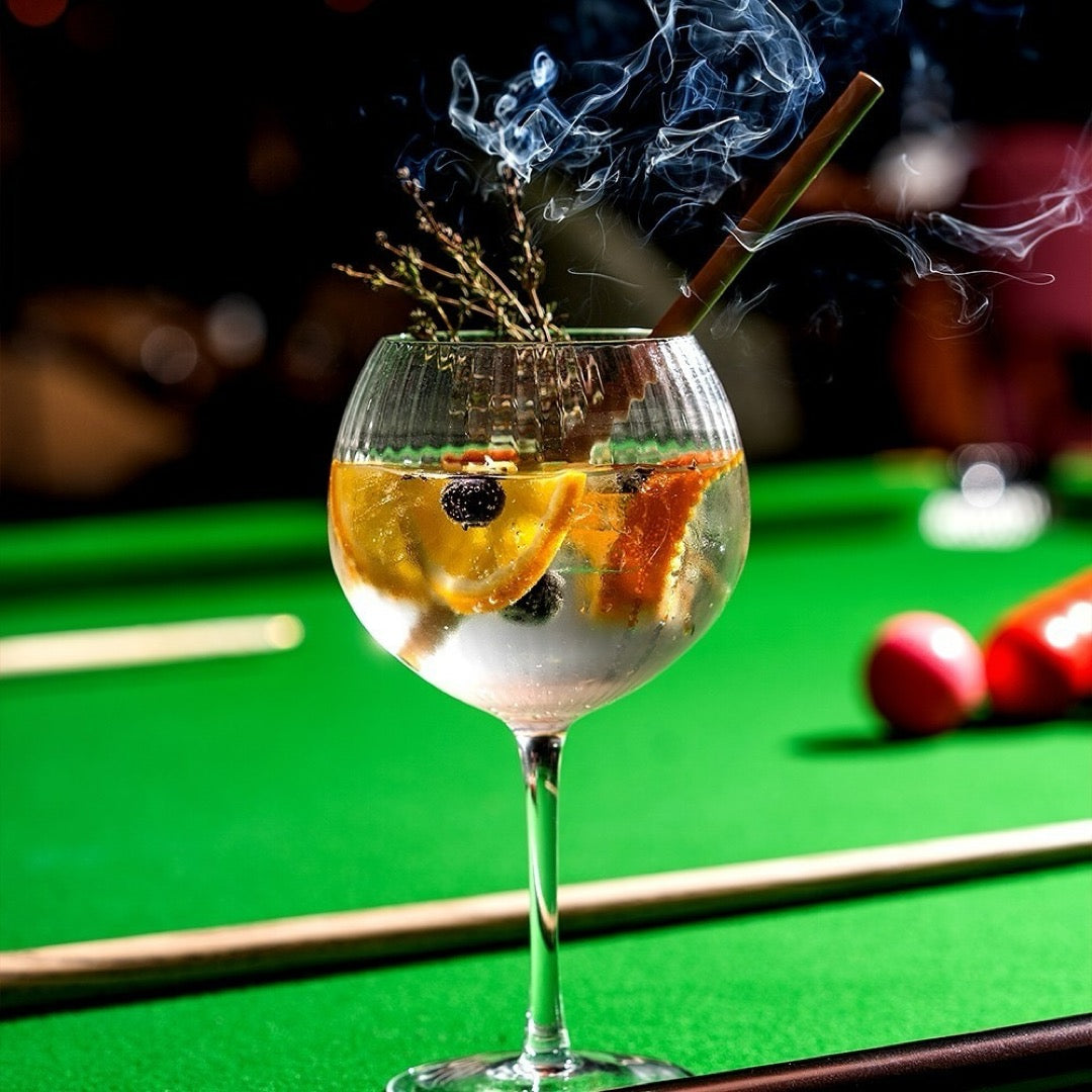 Stylish ribbed glass with gin tonic, orange, and thyme.