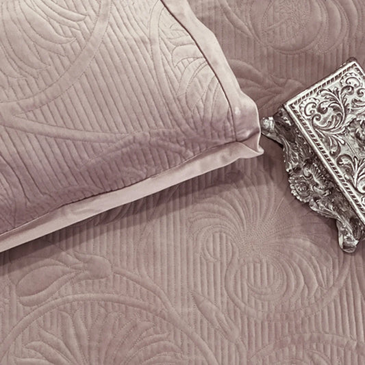 Onion pink velvet bedspread with quilted floral pattern.