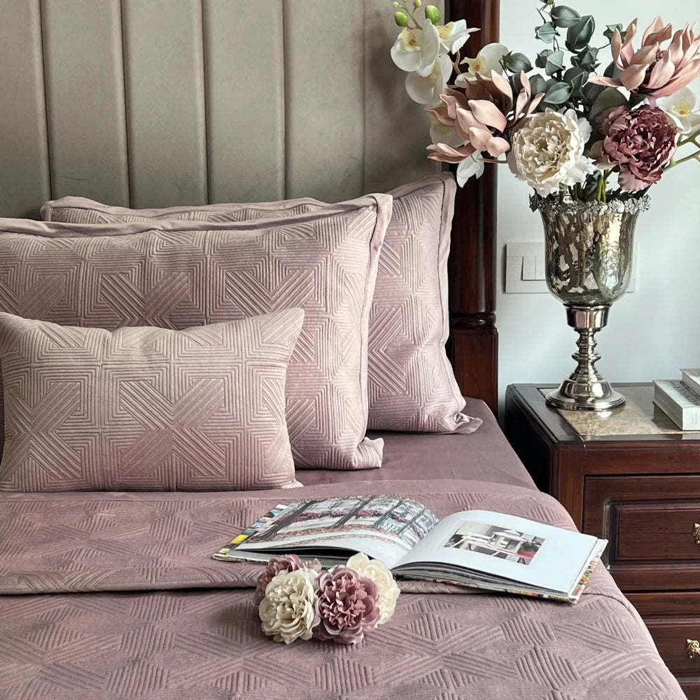 Onion pink velvet bedspread with geometric pattern.