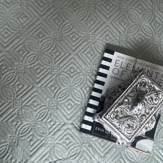 Sage green cotton reversible bedspread with geometric pattern.