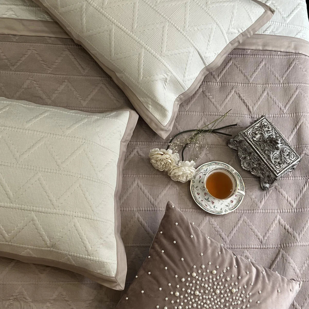 Buff ivory trigon cotton bedspread with matching pillows displayed.
