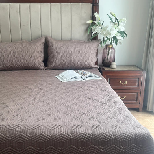 Taupe cotton bedspread with geometric pattern and matching pillow shams.