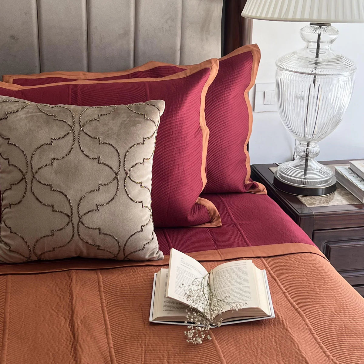 Rosette pattern reversible bedspread in maroon and rust cotton.