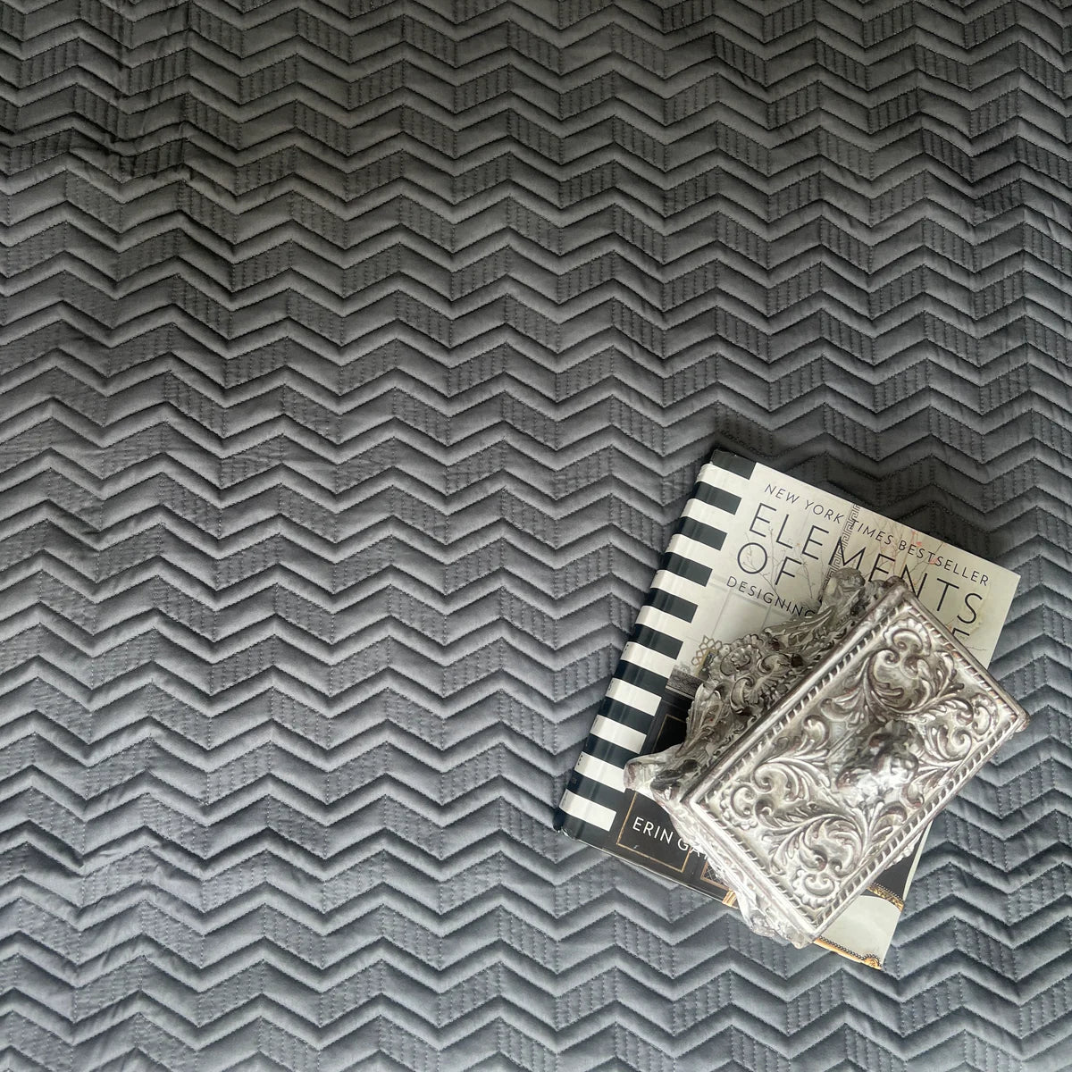 Dark grey cotton bedspread with chevron pattern.