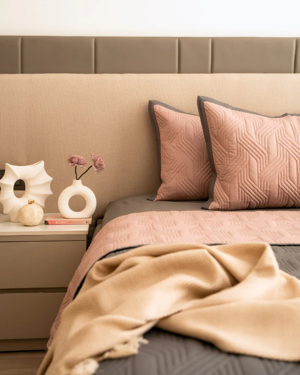 Quilted old rose bedspread with grey reversible side and matching pillow shams.