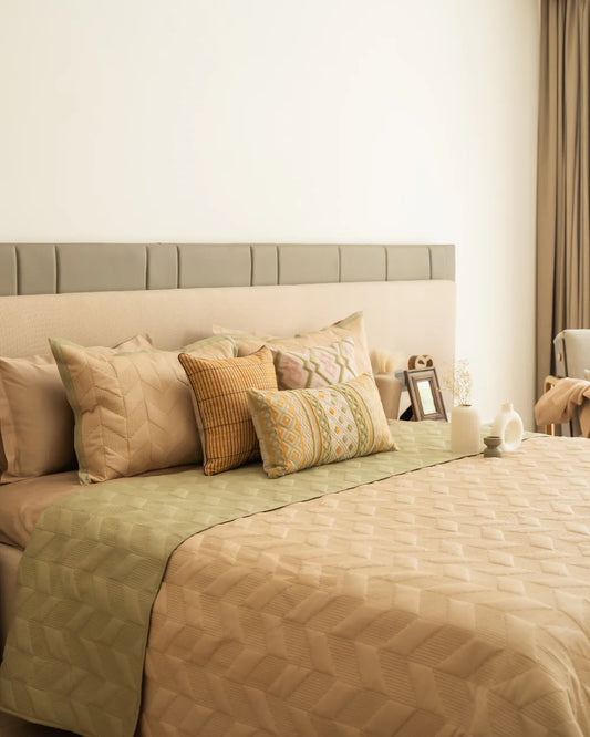 Quilted reversible bedspread in forest green and sand colors with geometric pattern.