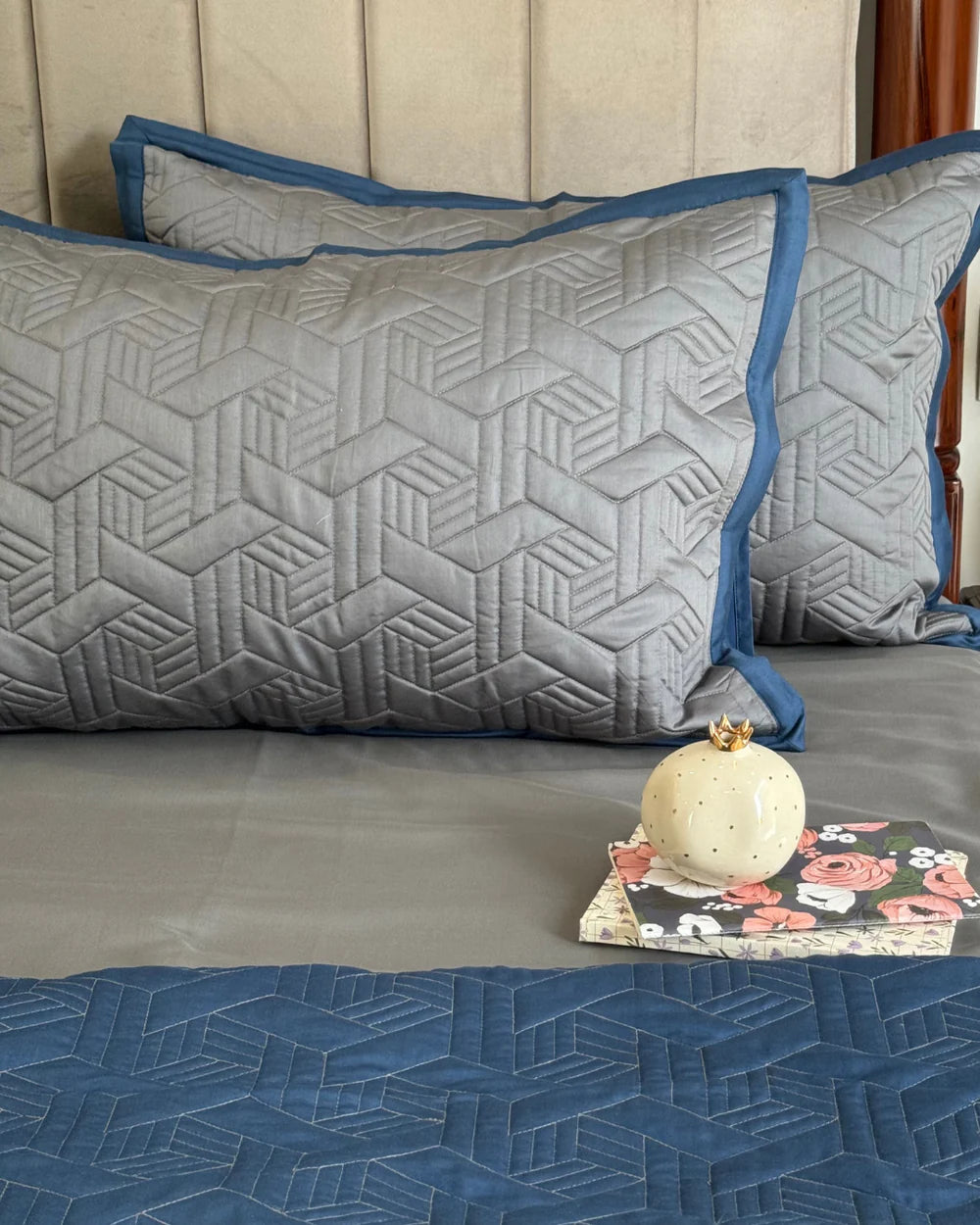 Navy and grey reversible bedspread with geometric quilt pattern.