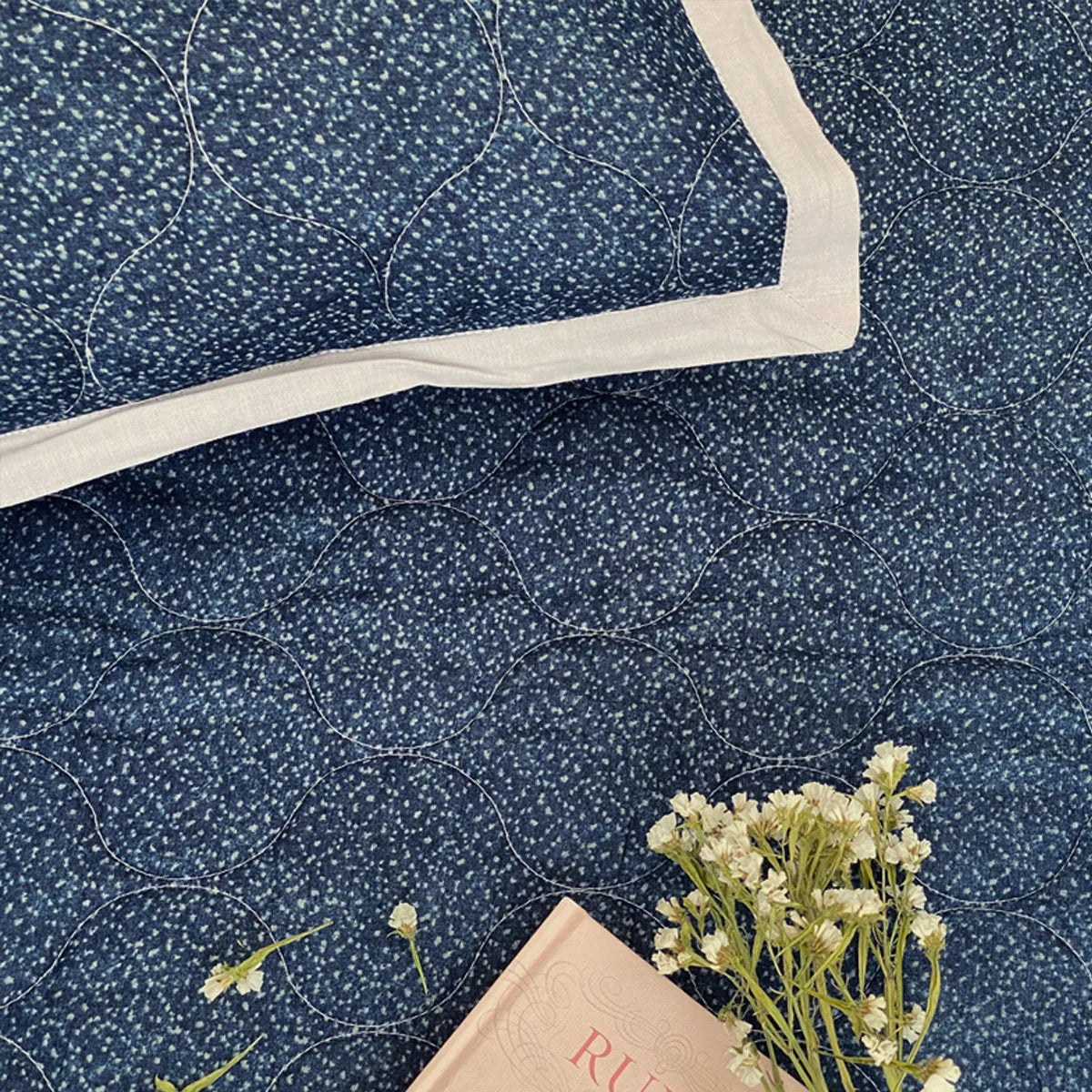 Indigo cotton bedspread with reversible pattern and white trim.