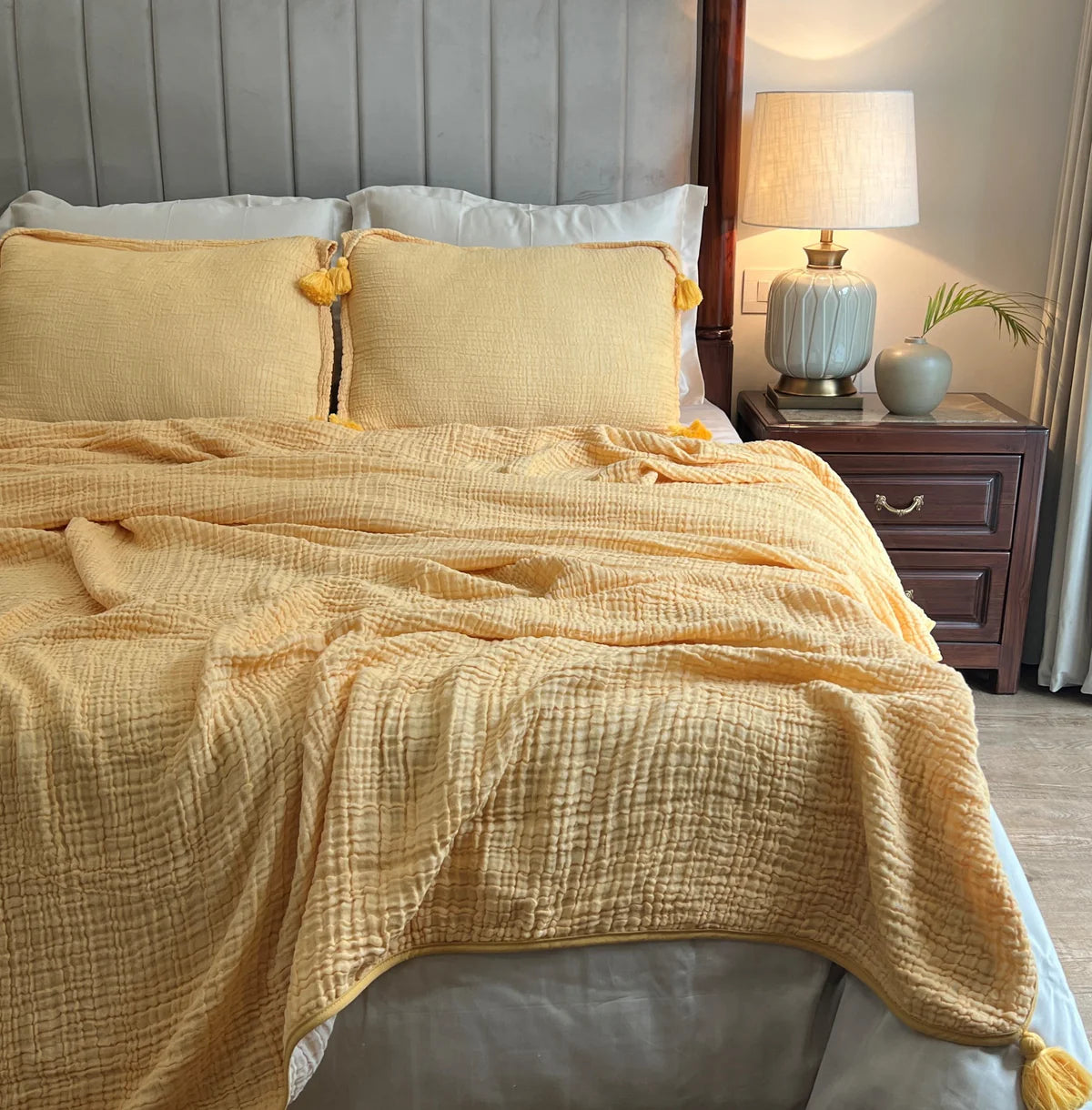 Buttercup yellow woven bedspread with textured pattern and tassel details.