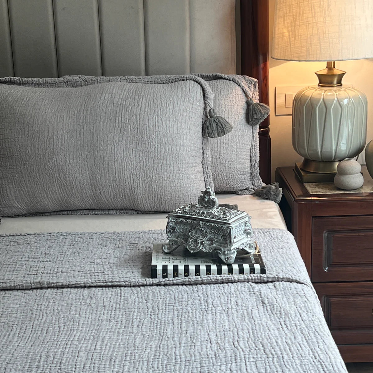 Slate woven bedspread with matching pillow and tassels.