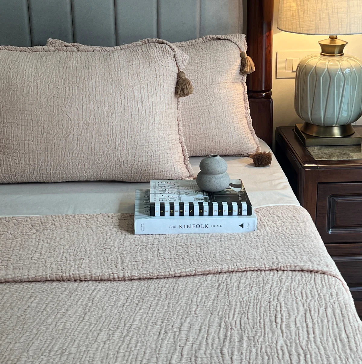 Sage woven bedspread with matching textured pillow covers and tassel accents.