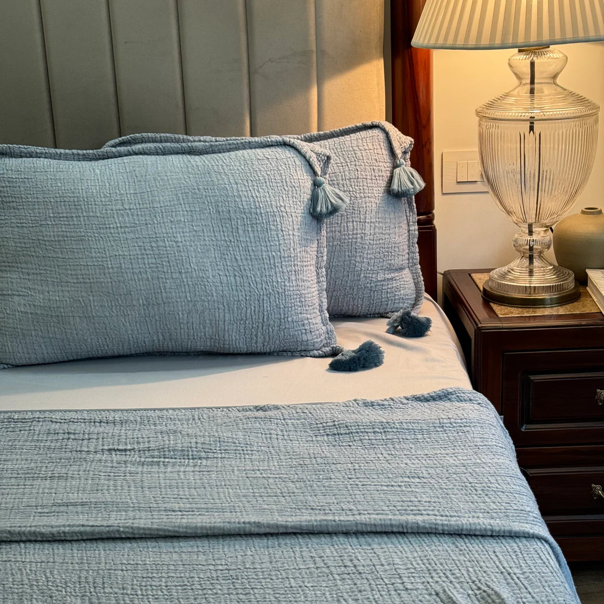 Indigo woven bedspread with textured pattern and tassel details.