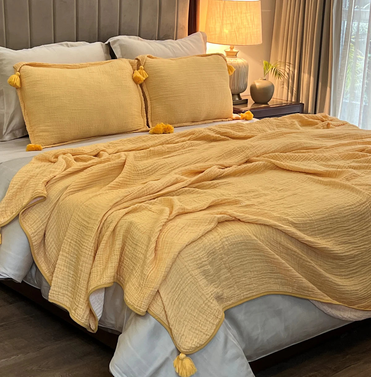 Buttercup yellow woven bedspread with tassel details on shams and corners.