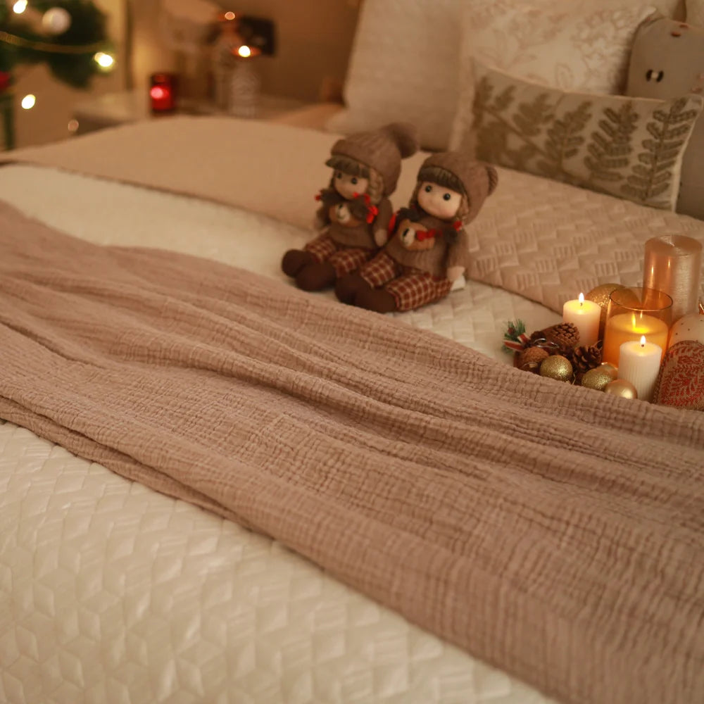 Beige woven bedspread with soft texture on a decorated bed.