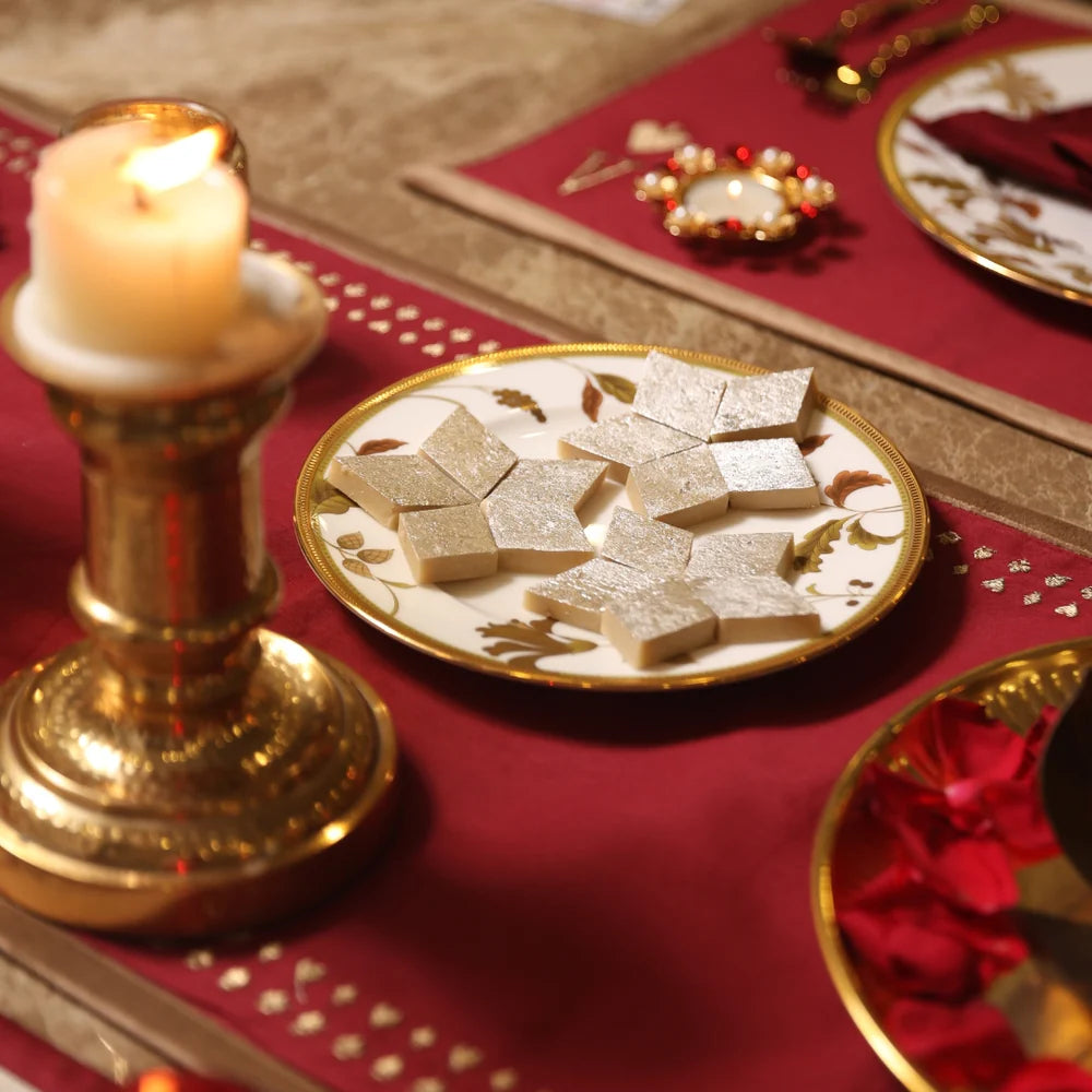 Red embroidered table runner with decorative dining setup for a festive occasion