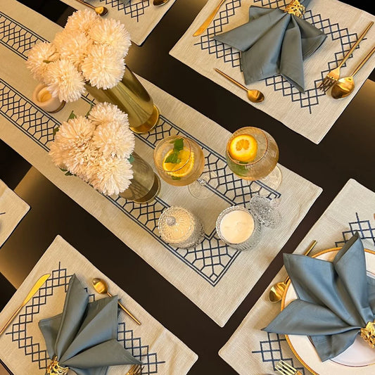 Sage green table linen set with zigzag design and gold cutlery.