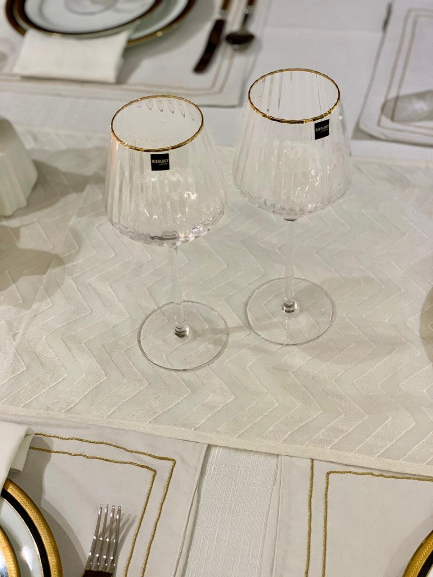 Elegant ridged red wine glass with a gold rim.