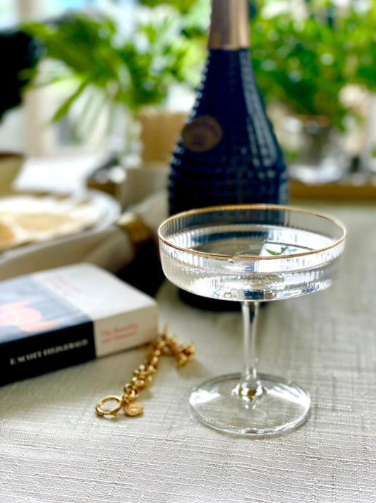 Elegant coupe glass with gold rim detail on set table.