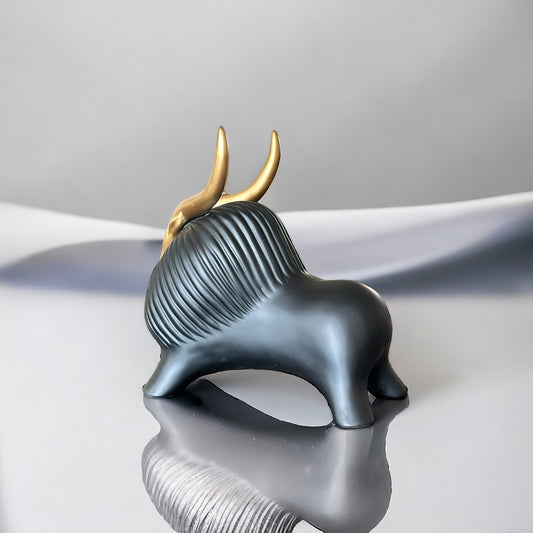 Black yak decor with gold horns; modern figurine.