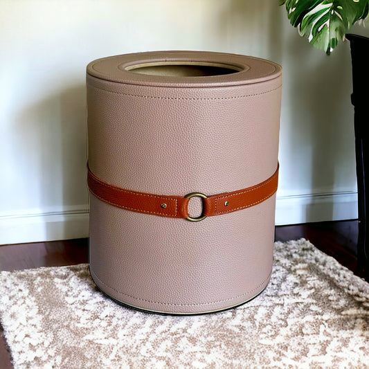 Beige wastebin with brown belt, stylish container.