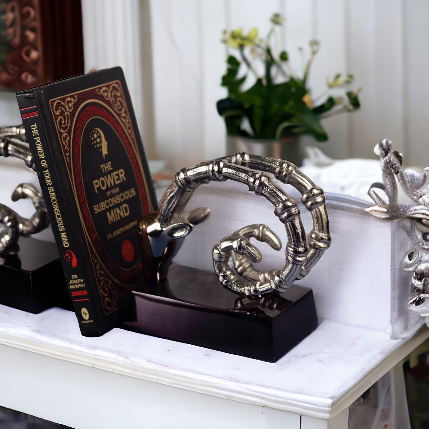 Skeletal hand bookends holding book on subconscious mind