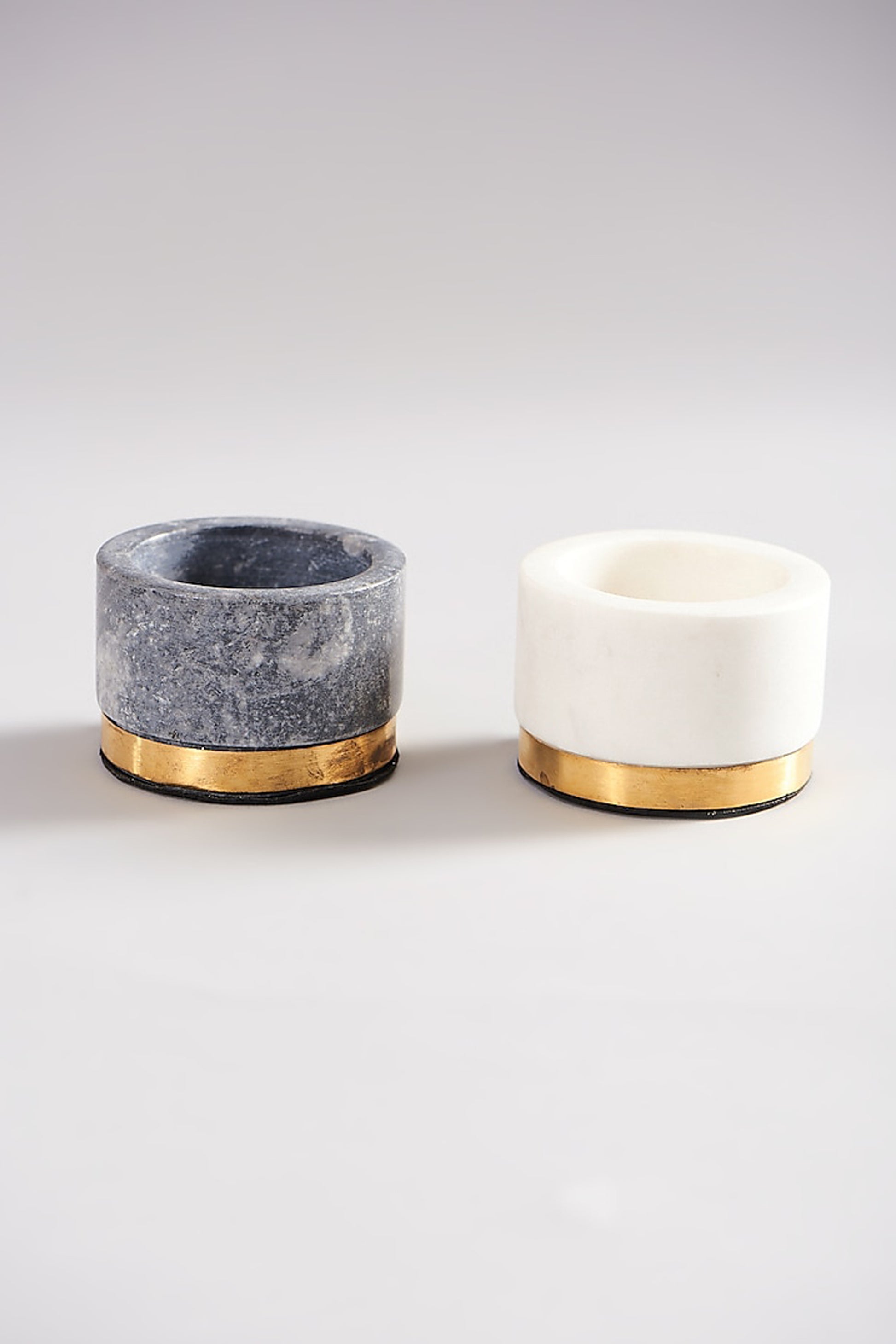 Two marble condiment bowls with brass accents; grey and white.