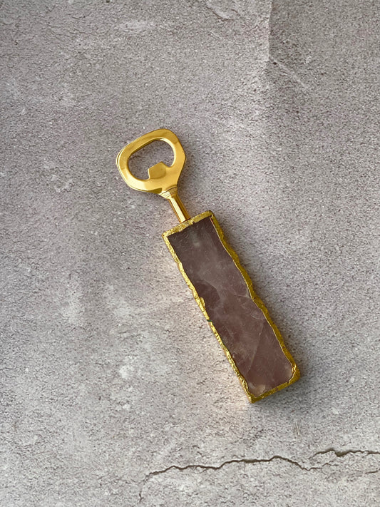 Elegant rose quartz bottle opener with gold trim.