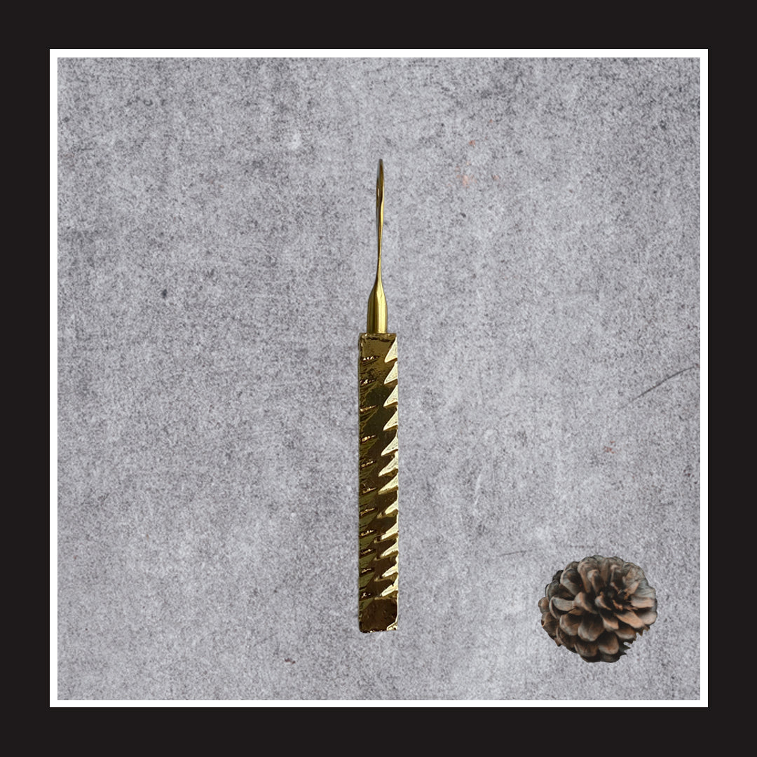 Golden textured bottle opener with geometric details.