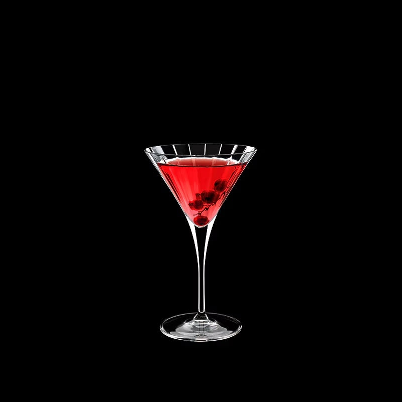 Elegant martini glass with red cocktail and berries detail.