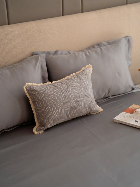 Slate grey bedsheet set styled on a bed with matching pillow covers