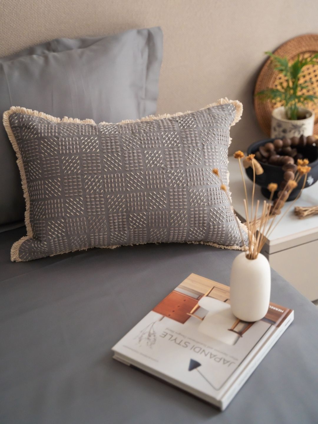 Embroidered accent cushion cover on the slate bedsheet set