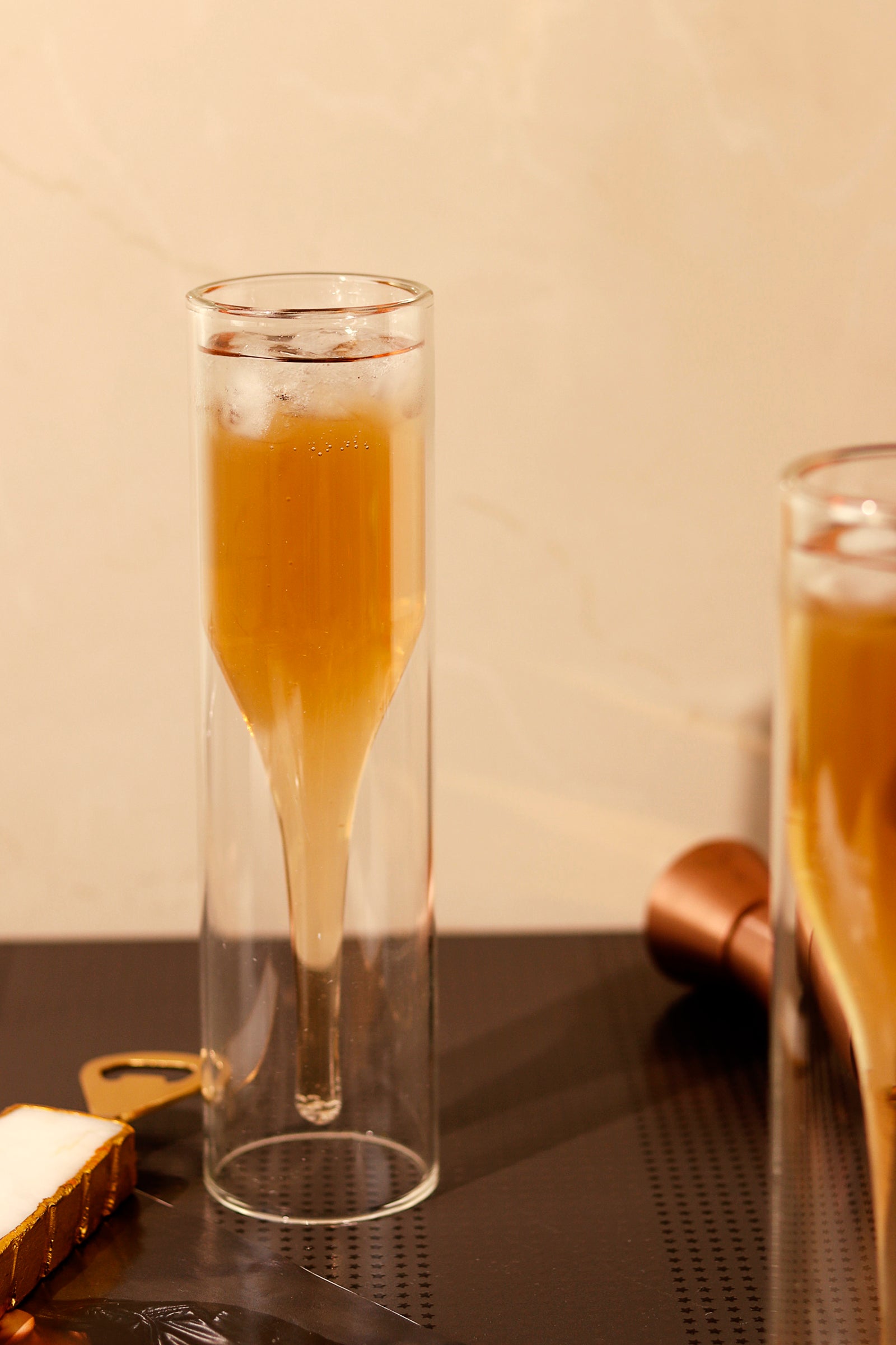 Double walled flute glass with beverage and ice, modern design.