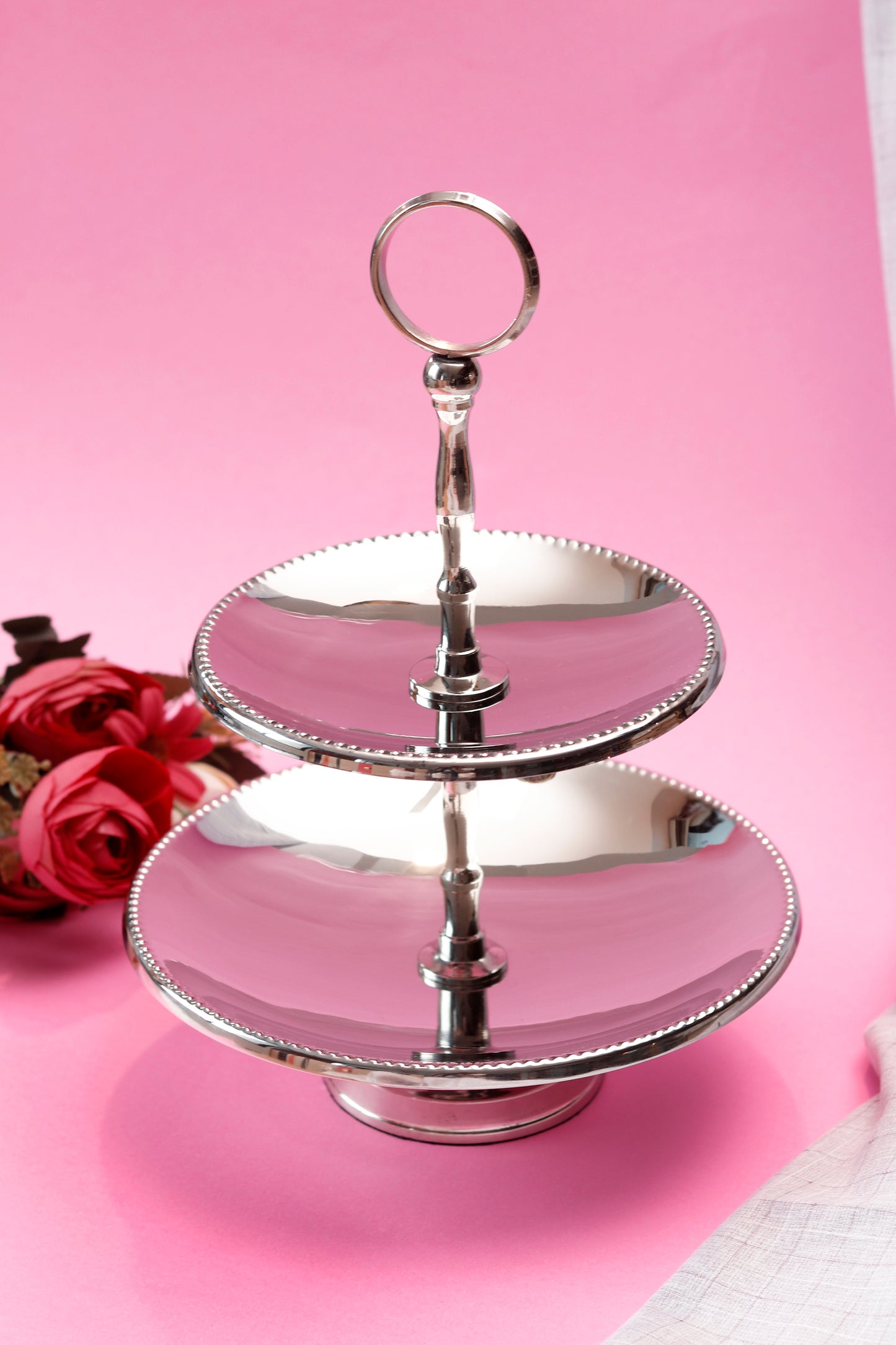 Silver two tier stand for cakes and cookies.