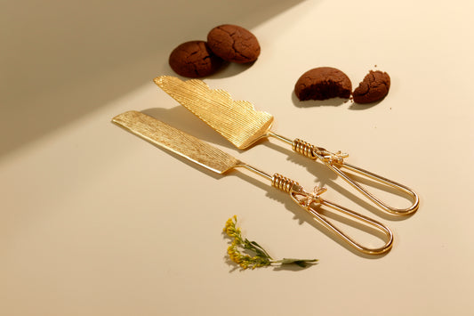 Golden firefly dessert knife and server set with cookies.