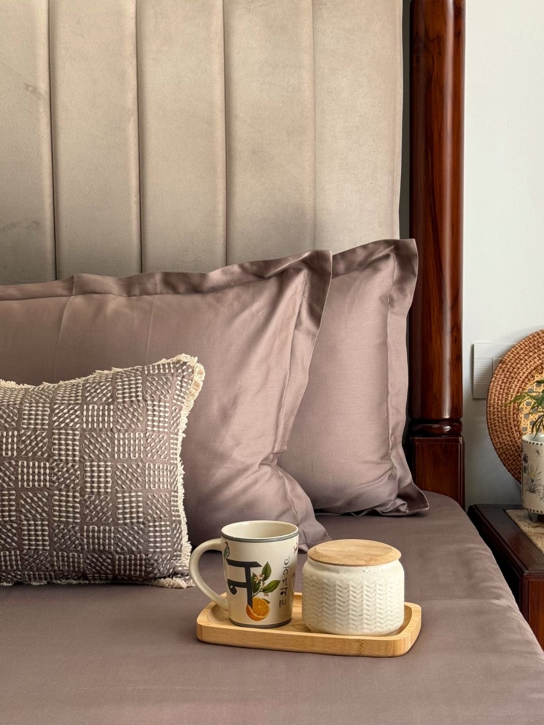 Taupe bedsheet set styled on a bed with matching pillows