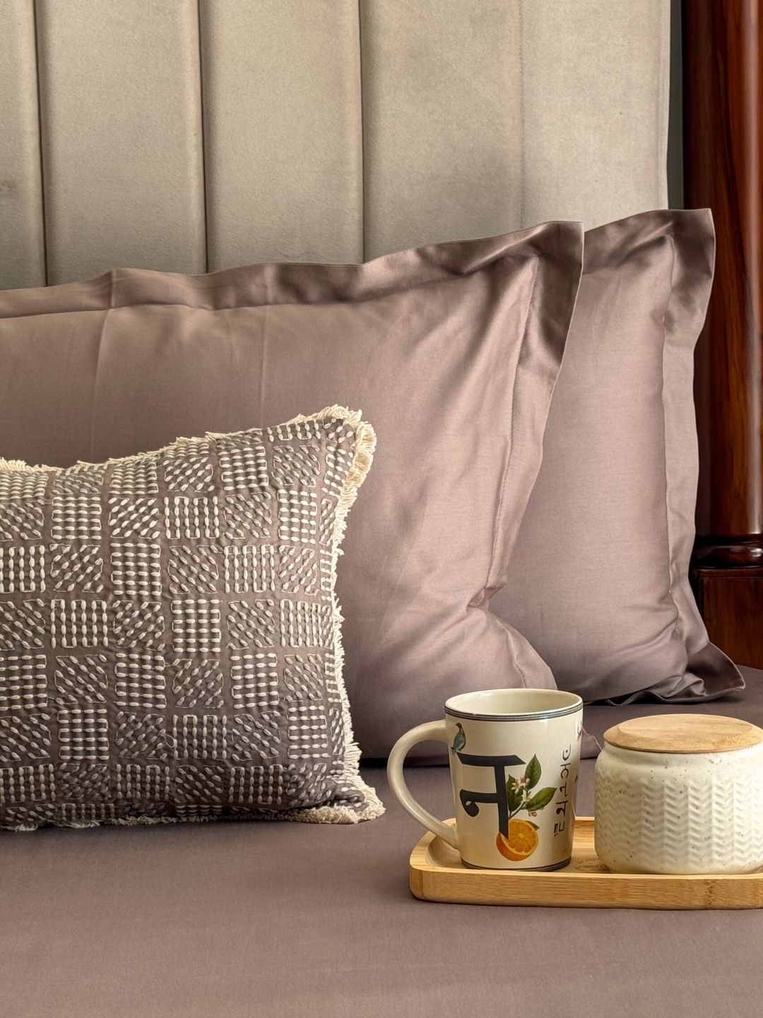 Folded taupe pillow covers and bedsheet set